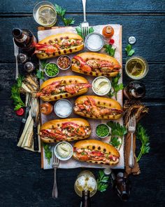 lobster sandwiches on bread with sauces and condiments laid out on a table