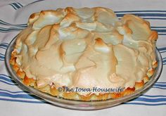 a pie sitting on top of a glass plate covered in frosted icing and toppings