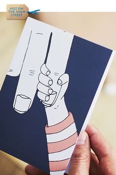 a person holding up a card with a drawing on it