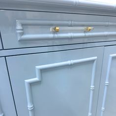 a close up of a white cabinet with gold handles