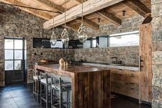 an open kitchen with stone walls and flooring is shown in this rustic style home