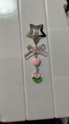 three charms are attached to the back of a cell phone holder on a white surface