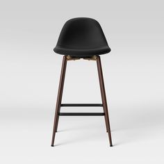 a black bar stool with wooden legs and an upholstered seat, on a white background