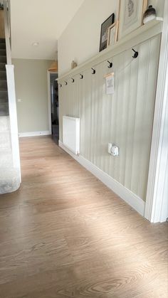 an empty hallway with wooden floors and white walls