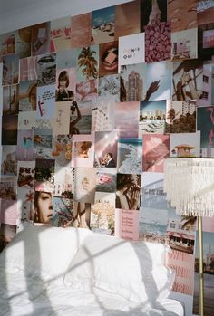 a white couch sitting in front of a wall covered with pictures and fringed curtains