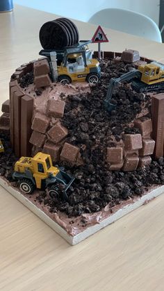 there is a cake that looks like construction equipment on top of dirt and rocks in the shape of a mountain