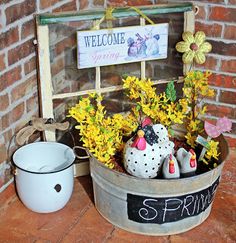 a welcome spring sign and potted plants in a bucket