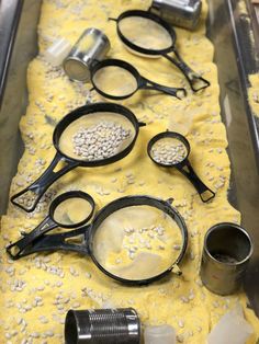 several pairs of scissors and measuring spoons on a yellow cloth with white speckles