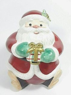 a ceramic santa clause holding a gingerbread