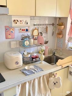 a kitchen with a sink, counter top and various cooking utensils on it