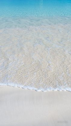 an ocean beach with white sand and blue water