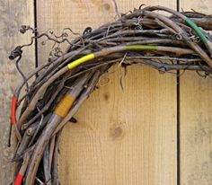 a wreath made out of twigs with crayons on the front and back ends