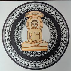 a buddha statue sitting on top of a black and white circular wall hanging above a doorway