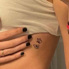 two women with tattoos on their stomachs, one has a butterfly and the other has a flower