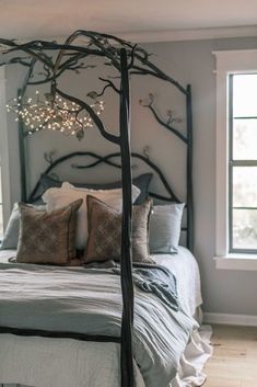 a bed with a canopy made out of branches and lights hanging from the headboard