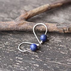 Lapis lazuli sterling silver earringsDainty 3/4" sterling silver budded open hoops with 6mm dark blue pyrite flecked lapis lazuli stones.Made to order ~ minor variations in stone character♥ Open hoops are applied to your ears by grasping the open ends in each hand and gently pulling one end up and one end down, then simply slide them in your ear. DO NOT pry them open then pinch them closed, they will lose shape and not close properly.HOW TO properly put on any kind of hoop earring. Copy and past Handmade Lapis Lazuli Jewelry For Everyday, Handmade Dangle Cartilage Earrings For Everyday Wear, Unique Handmade Sterling Silver Cartilage Earrings, Nickel-free Blue Cartilage Earrings As Gift, Handmade Minimalist Drop Cartilage Earrings, Unique Sterling Silver Cartilage Earrings With Ear Wire, Minimalist Handmade Dangle Cartilage Earrings, Minimalist Sterling Silver Earrings With Natural Stones, Minimalist Blue Wire Wrapped Earrings