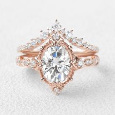 a rose gold engagement ring set with an oval cut diamond surrounded by small round diamonds