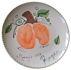 a plate with two oranges on it and the words mommy's little pumpkin