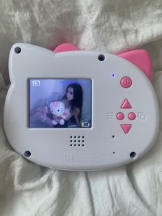 an electronic device with a hello kitty face on it's screen and pink ears