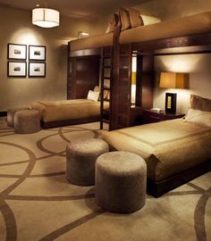 a bedroom with bunk beds and stools on the floor in front of two lamps