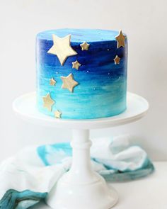 a blue and white cake with gold stars on it