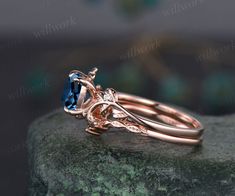 an engagement ring with a blue topazte stone in the center on a rock