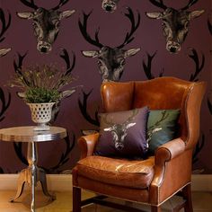 two deer head wallpapers in a living room next to a chair and table