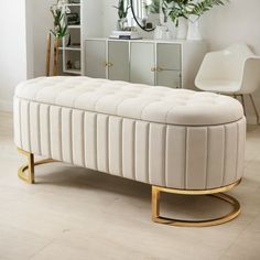 a white bench sitting on top of a hard wood floor next to a dresser and mirror