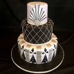 a three tiered cake decorated with black and white designs