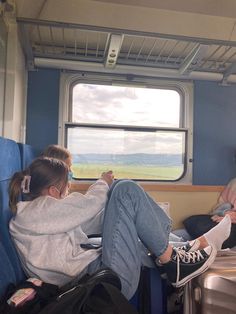 two people sitting on a train looking out the window