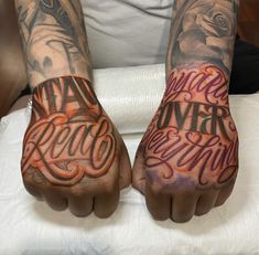 two hands with tattoos and writing on them