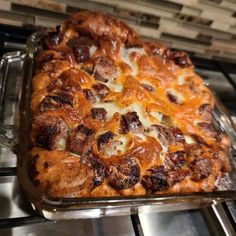 a pizza sitting on top of a metal pan covered in cheese and meat toppings