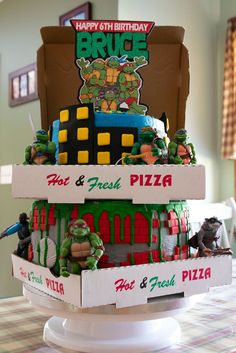 a birthday cake made to look like the teenage mutants are coming out of pizza boxes