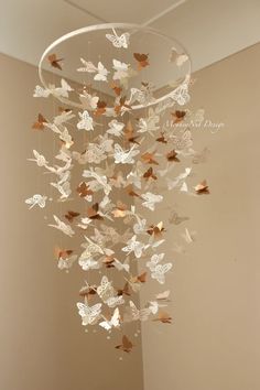 a wind chime with butterflies hanging from it's sides in a room next to a window