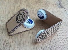 two empty beer bottle caps sitting on top of a wooden table next to a cardboard box