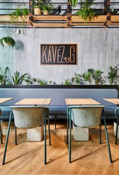 several tables and chairs with plants on the wall