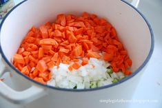 chopped carrots, onions and celery in a white pot on the stove