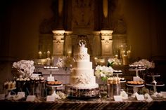 a table topped with a white cake and lots of cupcakes