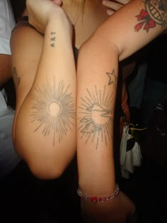 two people with tattoos on their arms