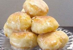 a pile of doughnuts sitting on top of a glass plate