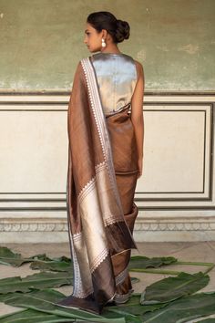 Grey, copper saree with floral meenakari borders and molten gold silver palla woven in kadau. Comes with running blouse piece.
Components: 1
Pattern: Woven
Type Of Work: Floral meenakari
Fabric: Silk Banarasi
Color: Grey
Other Details: 
Note: Stitched blouse worn by the model is not for sale
Disclaimer: The joint fabric pieces may vary. Designers unique process ensures that the placement of fabric will always be similar but not same. They always create the product with stretch fabrics of similar Copper Saree, Sari Blouses, Molten Gold, Silk Banarasi Saree, Sari Blouse, Handmade Textiles, Banarasi Saree, Gray Silk, Blouse For Women