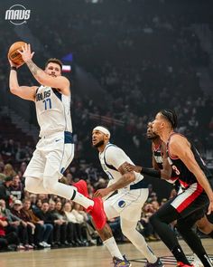 the basketball player is going to dunk the ball in front of two other players