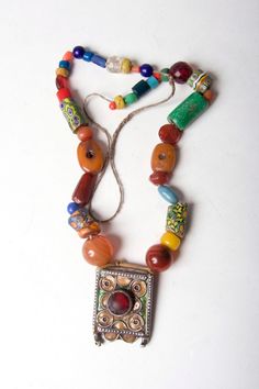 A mix of old beads, some very old, glass and resin, strung with an antique enamelled pendant which would once have been strung on a much richer necklace. Items like this would be passed down from mother to daughter and worn with many other necklaces and pendants. The pendant is worn and would have held silver coins but the bails have worn away over the years. Beeded Necklace, Mixed Bead Necklace, Moroccan Necklace, Mixed Beads Necklace, From Mother To Daughter, Mother To Daughter, Silver Coin Necklace, Moroccan Jewelry, Enamel Necklaces