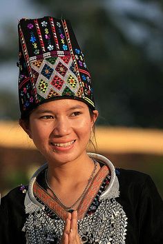 a young woman wearing a colorful headdress and smiling