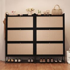 a black and beige cabinet with shoes on the bottom shelf next to a white bag