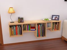 a book shelf with books on it next to a lamp