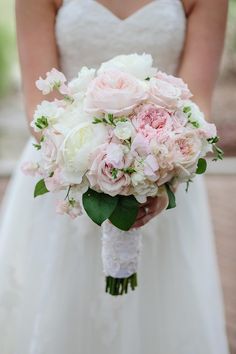 a bridal holding a bouquet of pink and white flowers