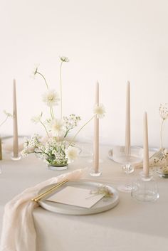 the table is set with flowers and candles