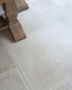 a wooden bench sitting on top of a tile floor