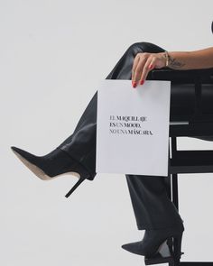 a woman sitting in a chair holding a sign